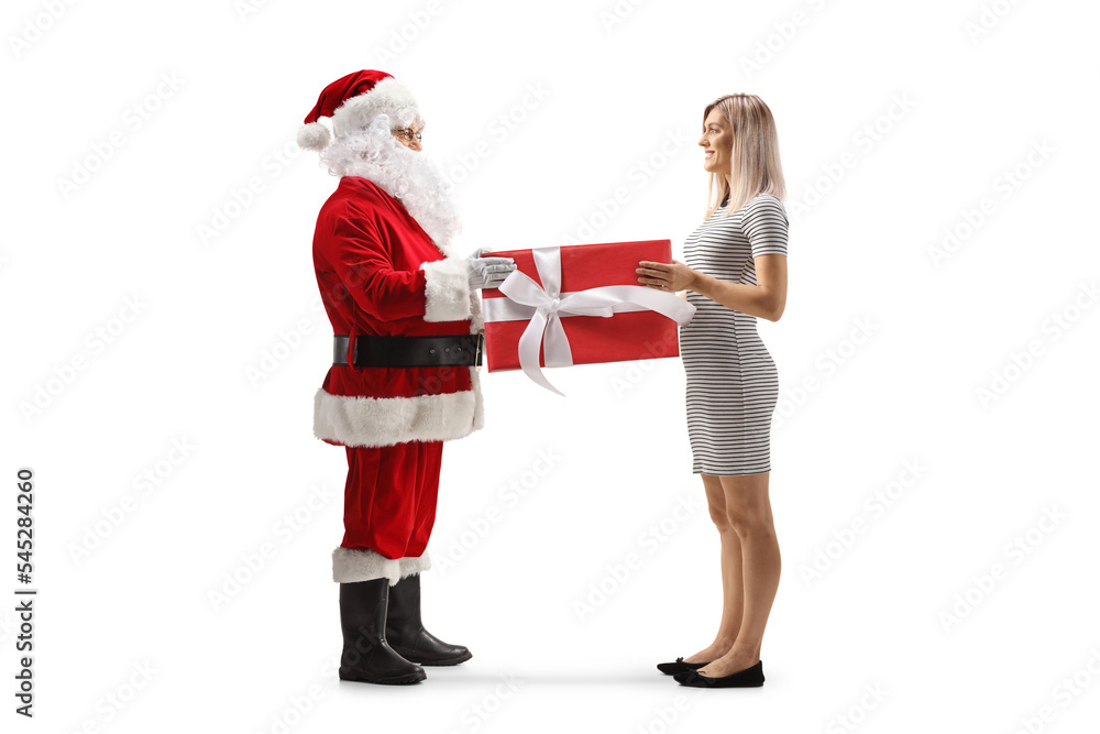 Full length profile shot of santa claus handing a present to a young woman Full length profile shot of santa claus handing a present to a young woman