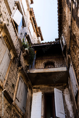 Streets with old buildings and the logo of Hajduk split football club in the old town of Trogir., Croatia. © Sulugiuc