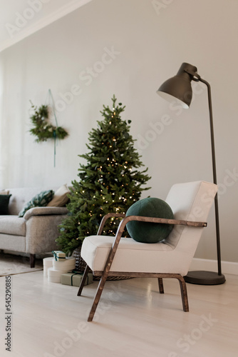 Christmas interior in scandinavian style with a sofa wreath chair and Christmas tree