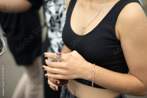 Girl hand. Summer clothes. Bare shoulder. Student holds something in her hand.