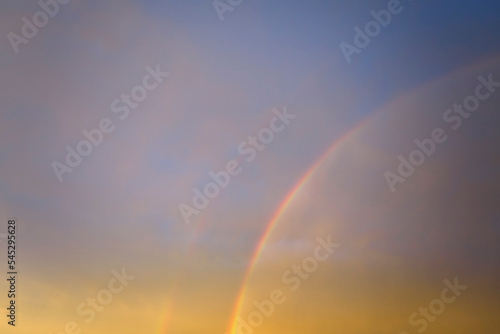 Colorful round rainbow against blue evening sky after heavy thunderstorm