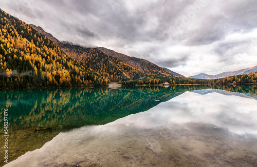 Golden autumn and beautiful reflections in the Anterselva lake. Alto Adige, Itlay. Excellent destination for family excursions too. photo