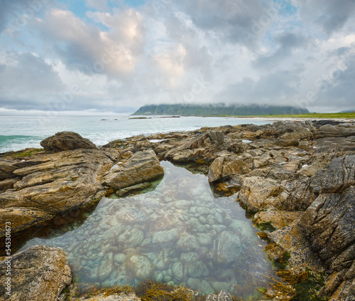 Summer cloudy view of the beach with pool in middle of stones ( Ramberg, Norway, Lofoten). photo