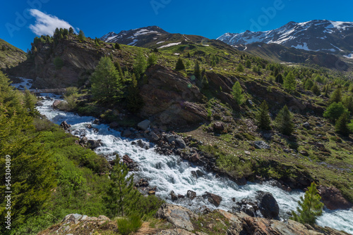 River stream in the mountains, Stelvio national park at clear sky, Italian alps © Aide