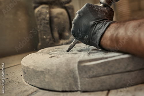 The craftsman works with stone with different tools. atmospheric photo. Sculpture making, handmade photo