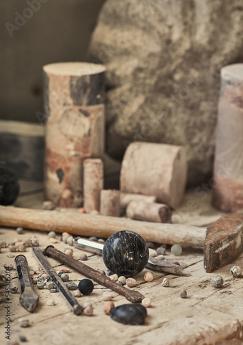background with various tools for working with stone. Stone sculptures in the background in the workshop. hand made photo