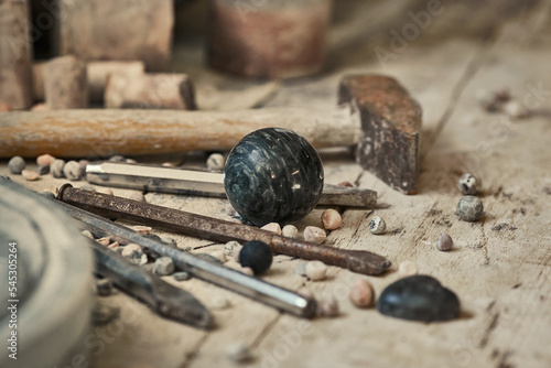 background with various tools for working with stone. Stone sculptures in the background in the workshop. hand made photo