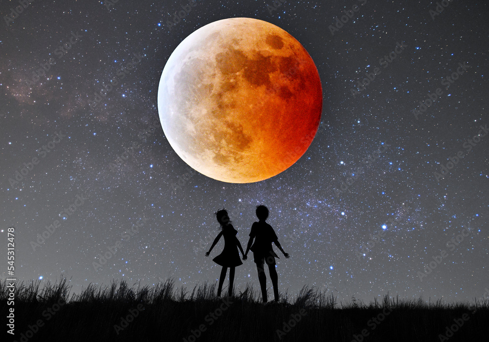 皆既月食で赤く染まった月を見上げるカップルのシルエット