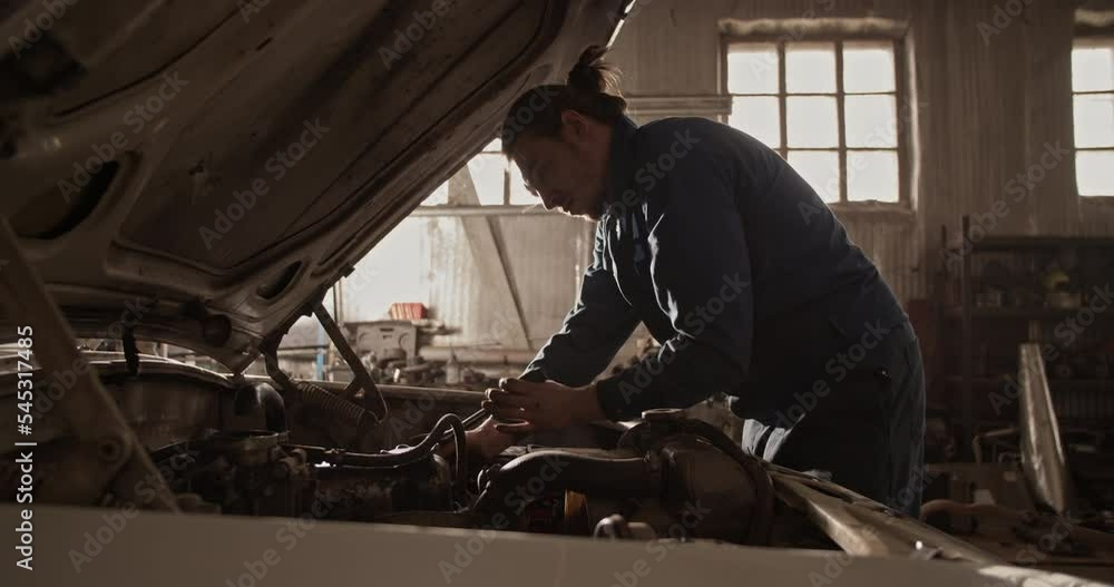 Man repairing car under sunlight Man repairing car under sunlight