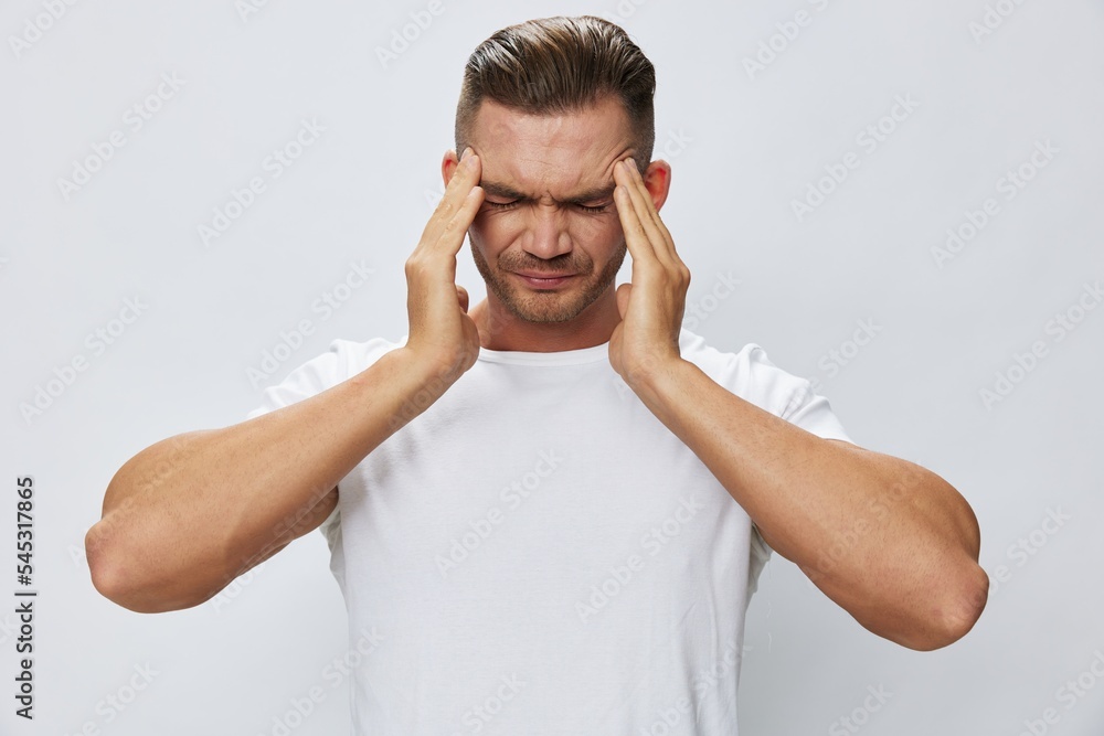 Man headache, migraine, high fever, in white T-shirt on white isolated background, copy space Man headache, migraine, high fever, in white T-shirt on white isolated background, copy space