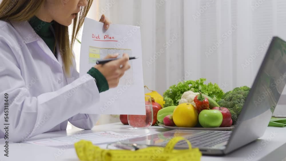 Female nutritionist shows and explains diet plan to her patient in