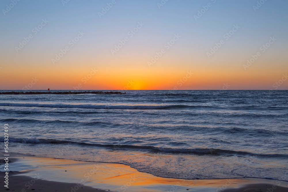 Blue-orange sunset on the sea. The last ray