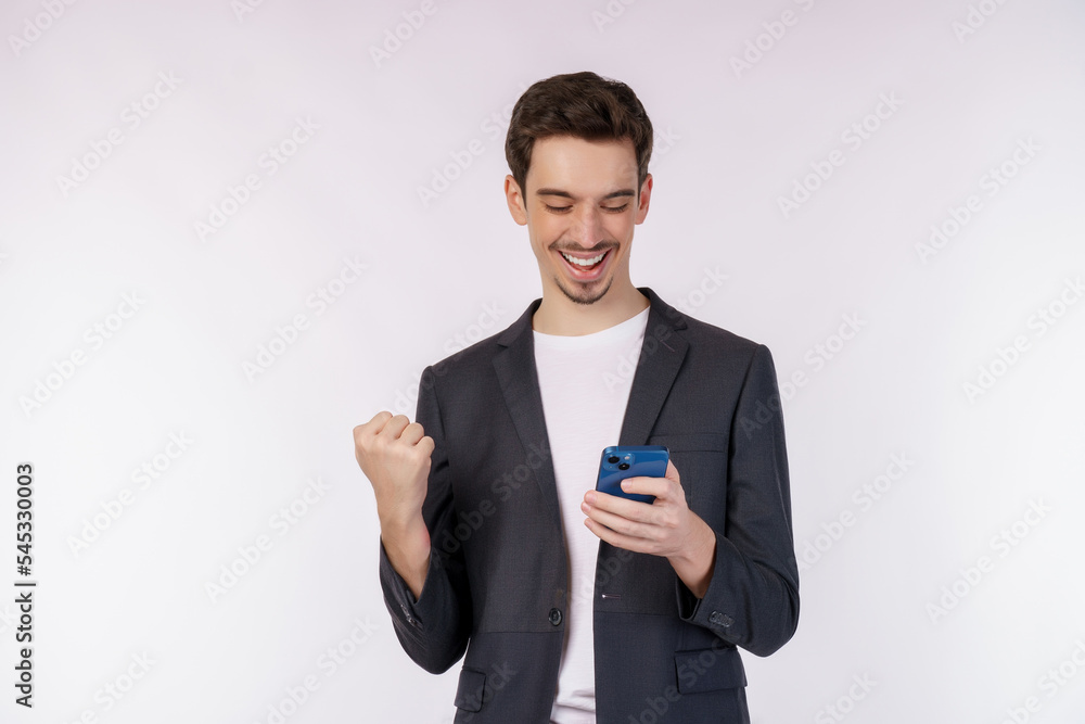 Portrait of a happy businessman using smartphone and doing winner gesture clenching fist over white background Portrait of a happy businessman using smartphone and doing winner gesture clenching fist over white background