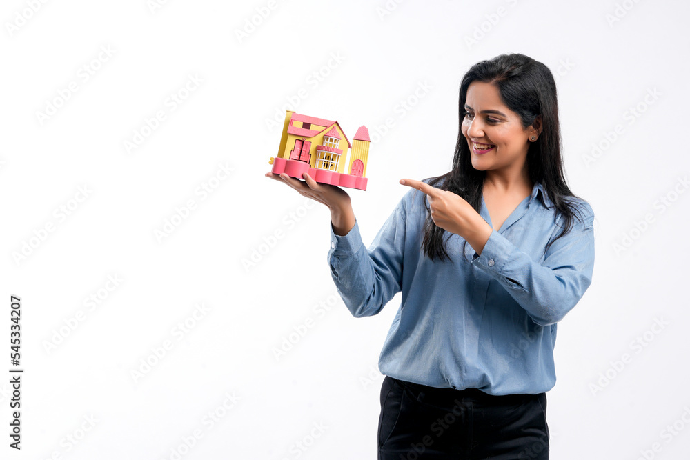 Indian woman holding home toy in hand. real estate concept. Indian woman holding home toy in hand. real estate concept.
