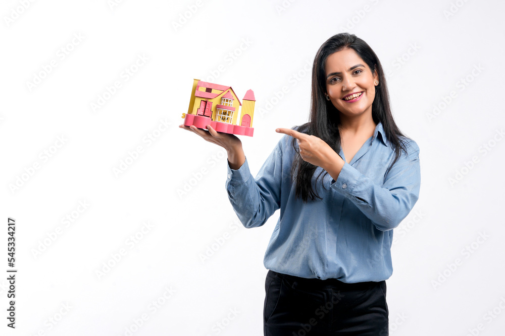 Indian woman holding home toy in hand. real estate concept. Indian woman holding home toy in hand. real estate concept.