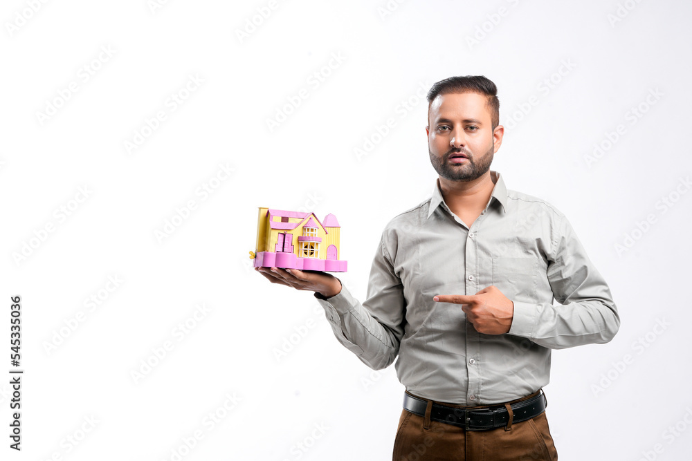 Indian man holding home toy in hand. dream home concept Indian man holding home toy in hand. dream home concept