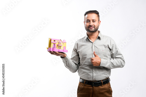 Indian man holding home toy in hand. dream home concept