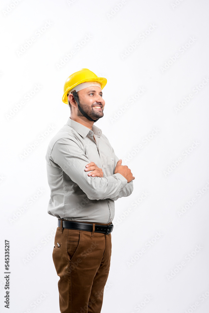 Young Indian engineer wearing yellow color hard hat and giving expression on white background. Young Indian engineer wearing yellow color hard hat and giving expression on white background.
