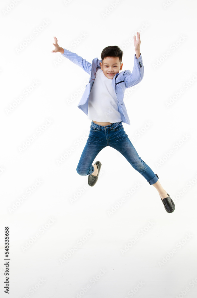 A 10-year-old Asian boy in a casual jacket is jumping smartly and happily looking at the camera against a white isolate background.