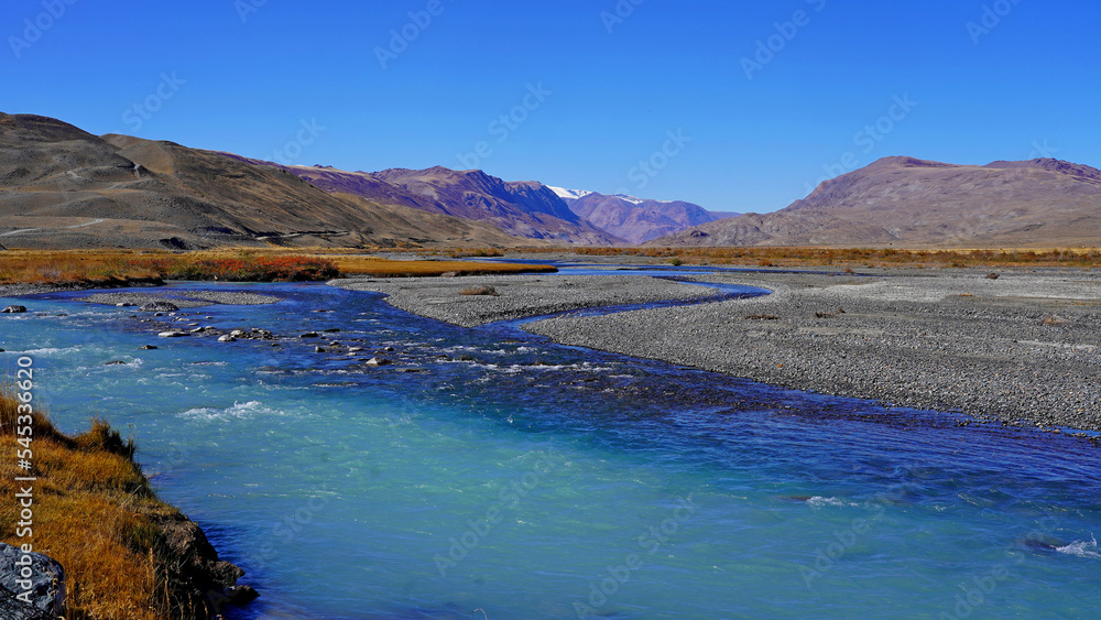 curved azure blue river through mountain peaks, autumn valley landscape