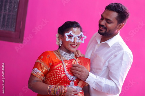 Attractive happy south Indian couple in traditional dress on pink background