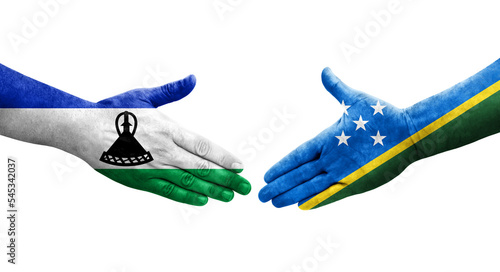 Handshake between Solomon Islands and Lesotho flags painted on hands, isolated transparent image.