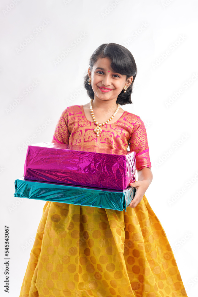 Cute indian little girl Child with gifts boxes in traditional cloths standing isolated over white background. Cute indian little girl Child with gifts boxes in traditional cloths standing isolated over white background.