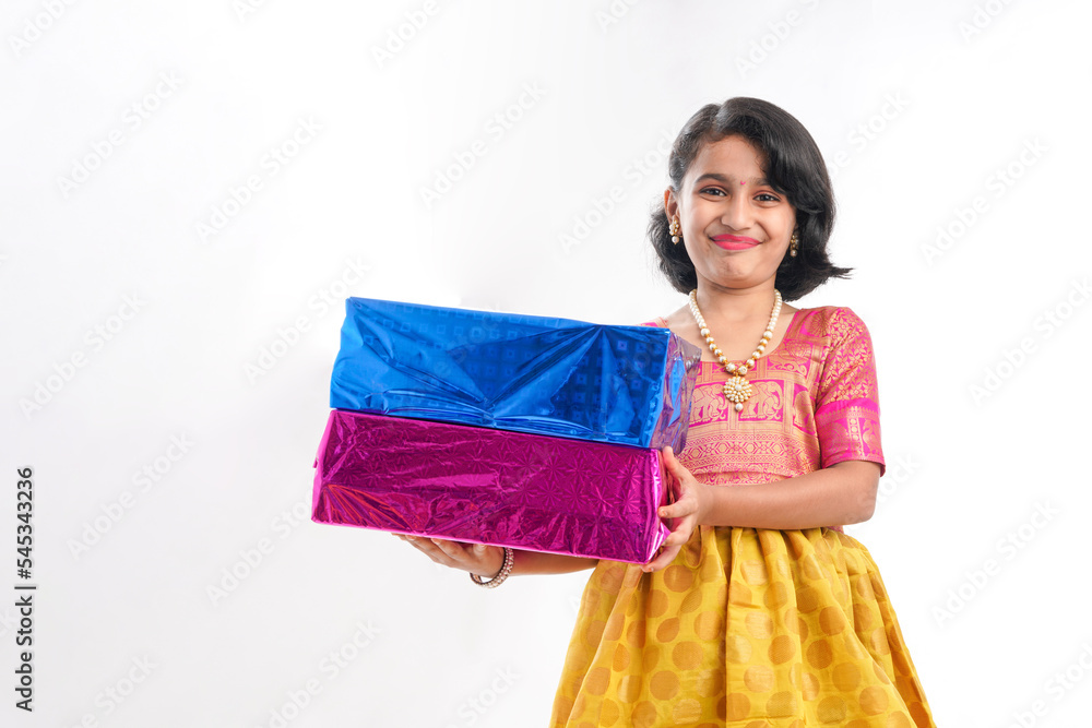 Cute indian little girl Child with gifts boxes in traditional cloths standing isolated over white background. Cute indian little girl Child with gifts boxes in traditional cloths standing isolated over white background.