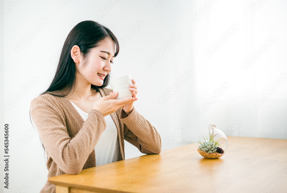 家で白湯・生姜湯・お茶を飲む日本人女性（温活）
