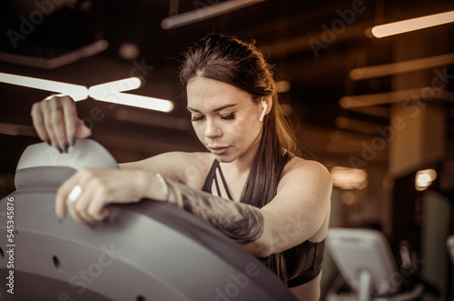 Portrait of tired fitness woman on treadmill in modern gym