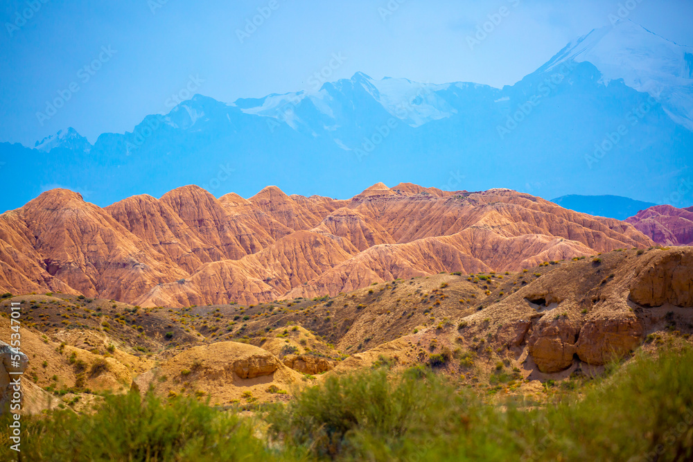 Natural unusual landscape of red rocks against the backdrop of blue mountains. The extraordinary beauty of nature is similar to the Martian landscape. Amazingly beautiful landscape. Natural unusual landscape of red rocks against the backdrop of blue mountains. The extraordinary beauty of nature is similar to the Martian landscape. Amazingly beautiful landscape.