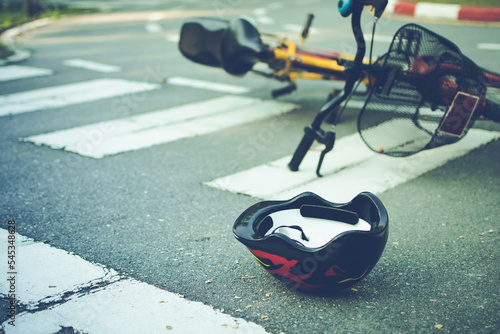 Fotografia Helmet and bike lying on the road on a pedestrian crossing, after accident