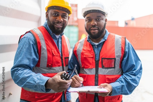 Fotomurale Portrait photo of the moment of two black african male container engineers worki
