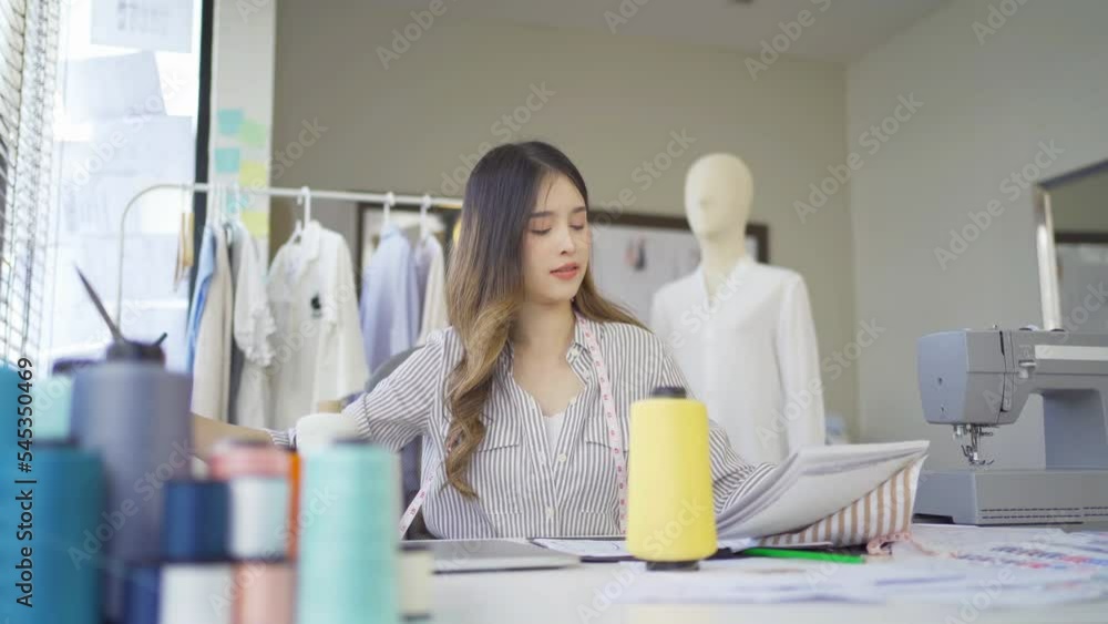 Portrait of freelance designer, tailor, stylist artist Asian woman, Thai person working online on fashion design clothes and costume shirts at home or house. People lifestyle. Creativity business. Portrait of freelance designer, tailor, stylist artist Asian woman, Thai person working online on fashion design clothes and costume shirts at home or house. People lifestyle. Creativity business.
