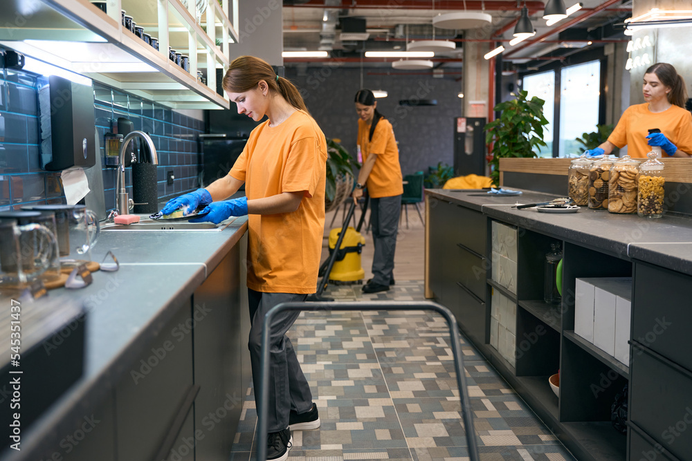 Team cleaners do general cleaning in kitchen area coworking space Team cleaners do general cleaning in kitchen area coworking space