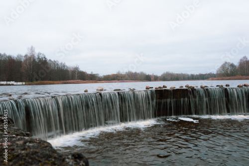 A small man-made waterfall on the lake. Lined with stones  the water froze in flight. Landscape.