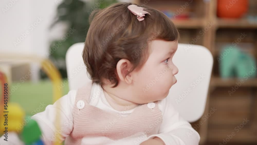 Adorable toddler sitting on table playing at kindergarten Adorable toddler sitting on table playing at kindergarten