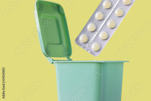 plastic blister thrown in mini small trash garbage bin can.expired pills blister with removed missing tablets isolated.unused or expired medicine drop off recycle.safe drug disposal.get rid throw away