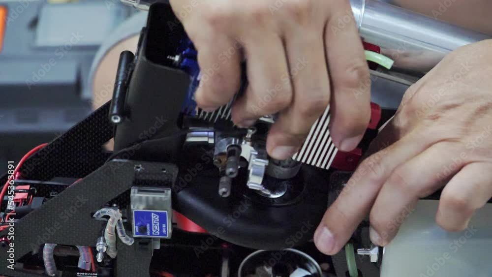 Man's hand holding the engine of an RC plane, he is repairing it. Man's hand holding the engine of an RC plane, he is repairing it.