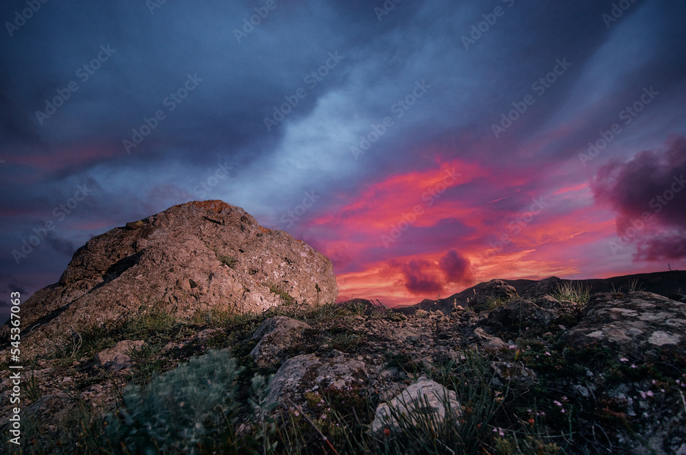 Beautiful landscape with big rocks against colorful sunset sky.
