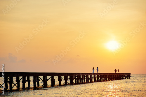 Pier on the sea shore at sunset time. © luengo_ua