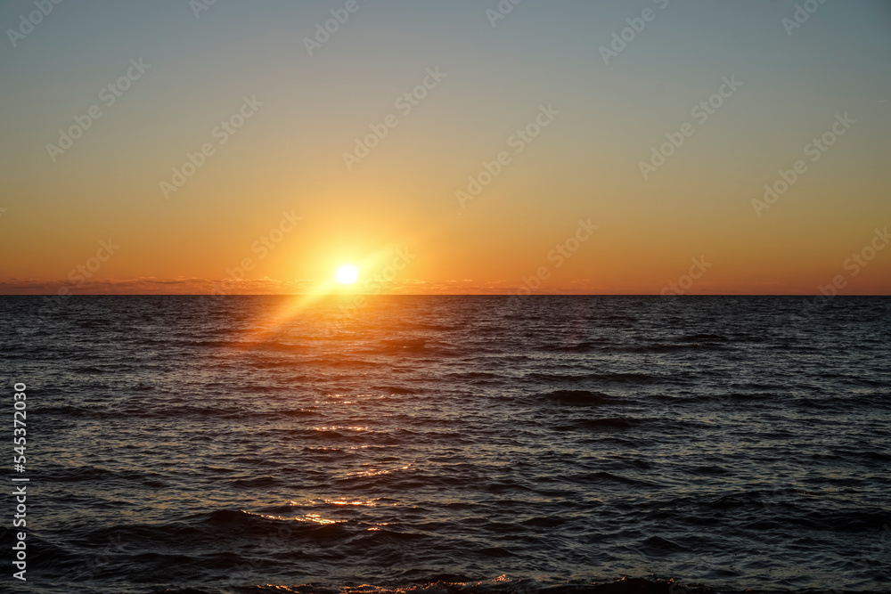 sunset at sea. variety of colors and hues of the rising sun. Sea landscape. Sun set by the sea, the sky is reflected in the smooth ocean