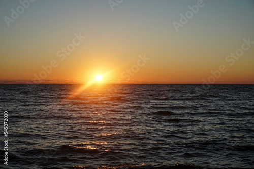 sunset at sea. variety of colors and hues of the rising sun. Sea landscape. Sun set by the sea, the sky is reflected in the smooth ocean © Maxim Chuev