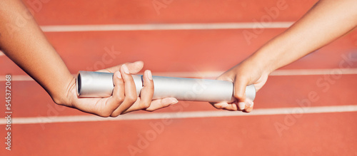 Hands, baton and relay with a sports woman and partner running a race with teamwork on a track. Fitness, health and exercise with a female athlete team racing in an athletics arena for competition