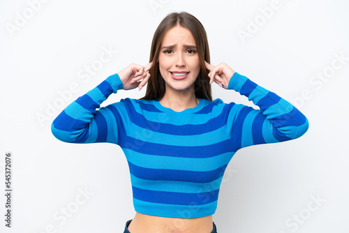 Young pretty caucasian woman isolated on white background frustrated and covering ears