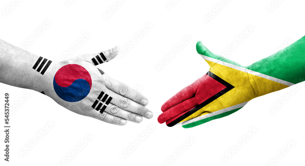 Handshake between South Korea and Guyana flags painted on hands, isolated transparent image. Handshake between South Korea and Guyana flags painted on hands, isolated transparent image.
