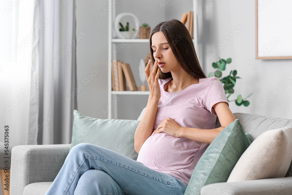 Young pregnant woman with nosebleed at home Young pregnant woman with nosebleed at home