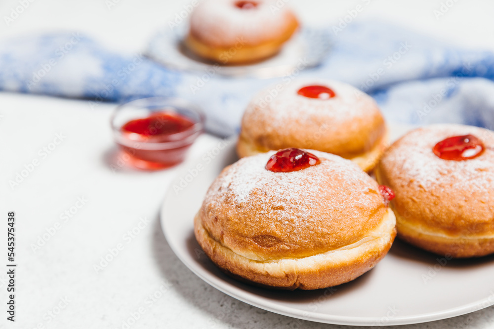 Sufganiyot jelly doughnuts cooked in oil on white table background. Traditional Jewish festive food dessert for Hanukkah holiday. Flat lay, top view.