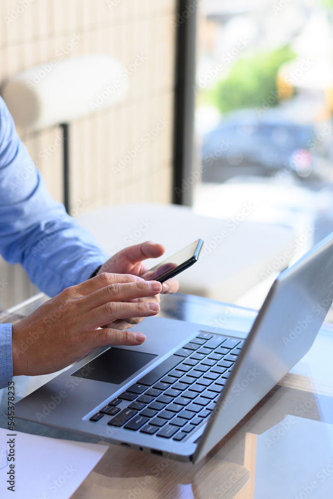 Businessman checking smartphone and laptop Businessman checking smartphone and laptop