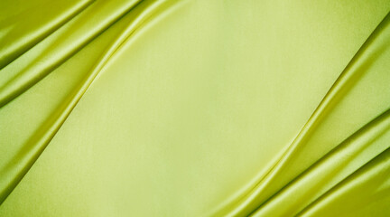 Yellow green silk satin. Lime color shiny silky smooth fabric. Soft wavy folds. Elegant background with space for design. Bright. Light. Banner. Flat lay, top view table. Template.